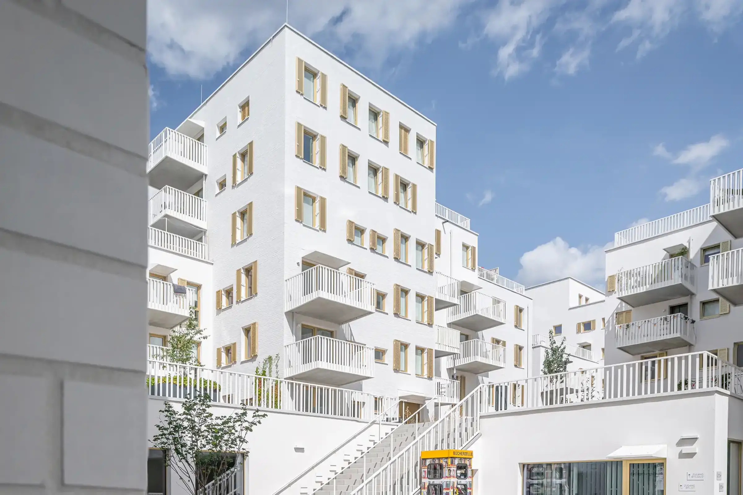 Aufnahme eines Wohnparks, Weiße Klinkerfassaden und goldene Fensterläden