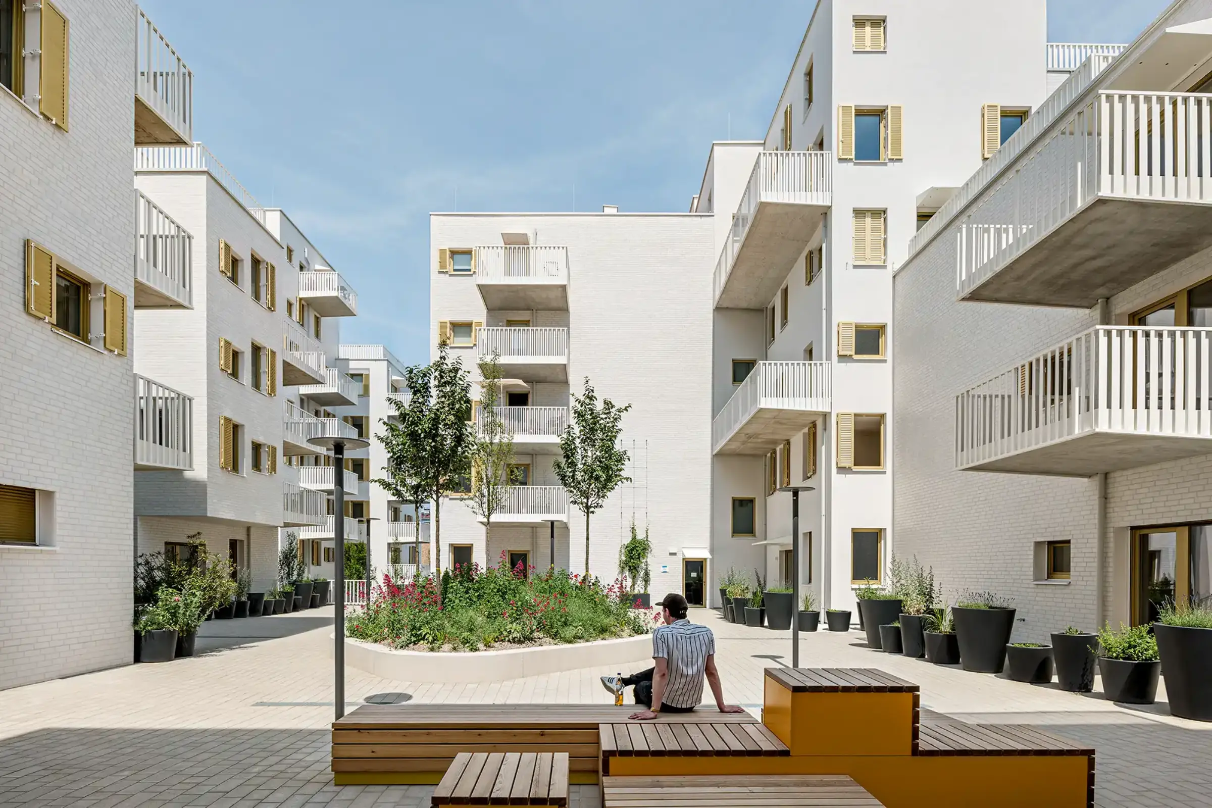 Aufnahme eines Wohnparks, Weiße Klinkerfassaden und goldene Fensterläden