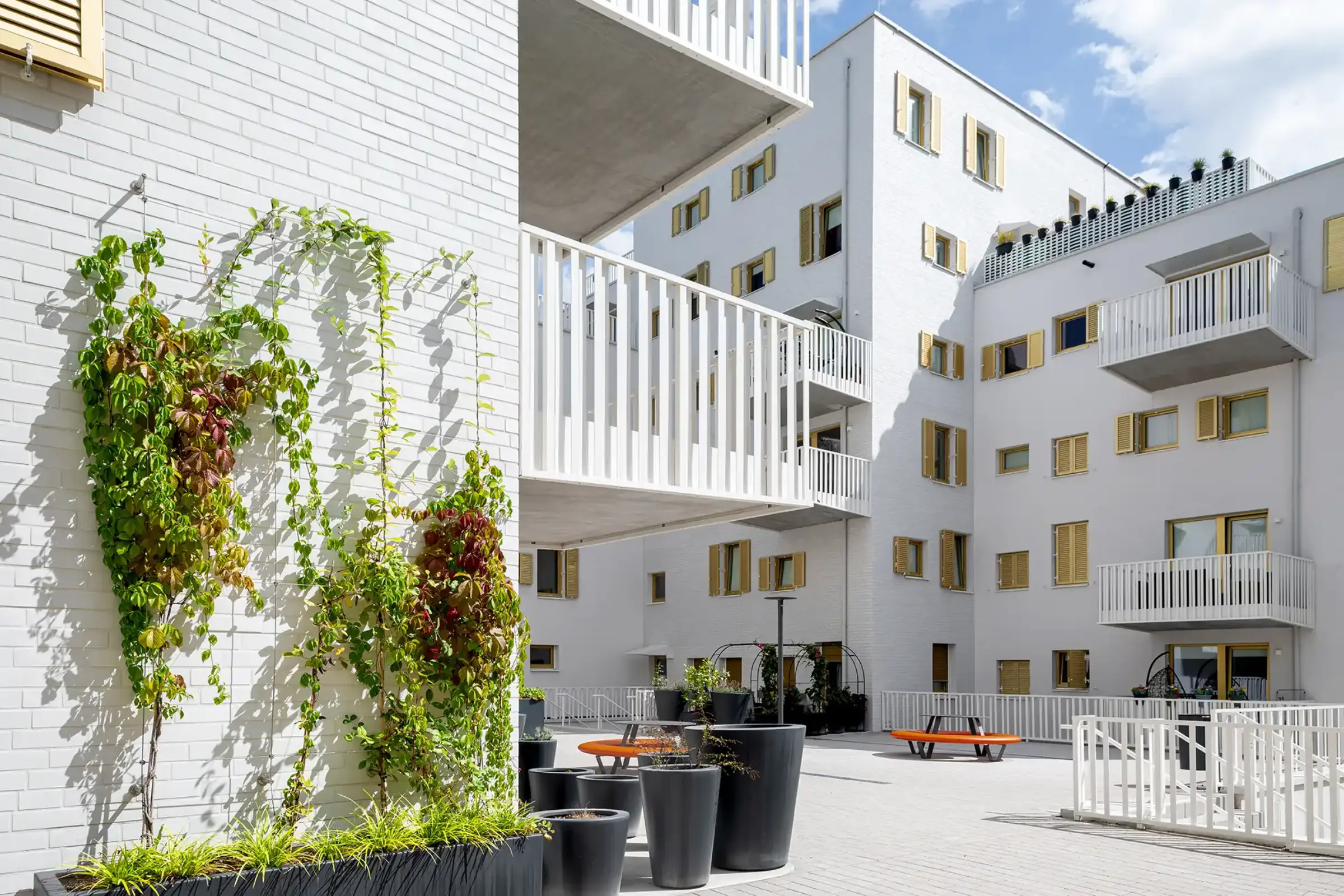 Aufnahme eines Wohnparks, Weiße Klinkerfassaden und goldene Fensterläden