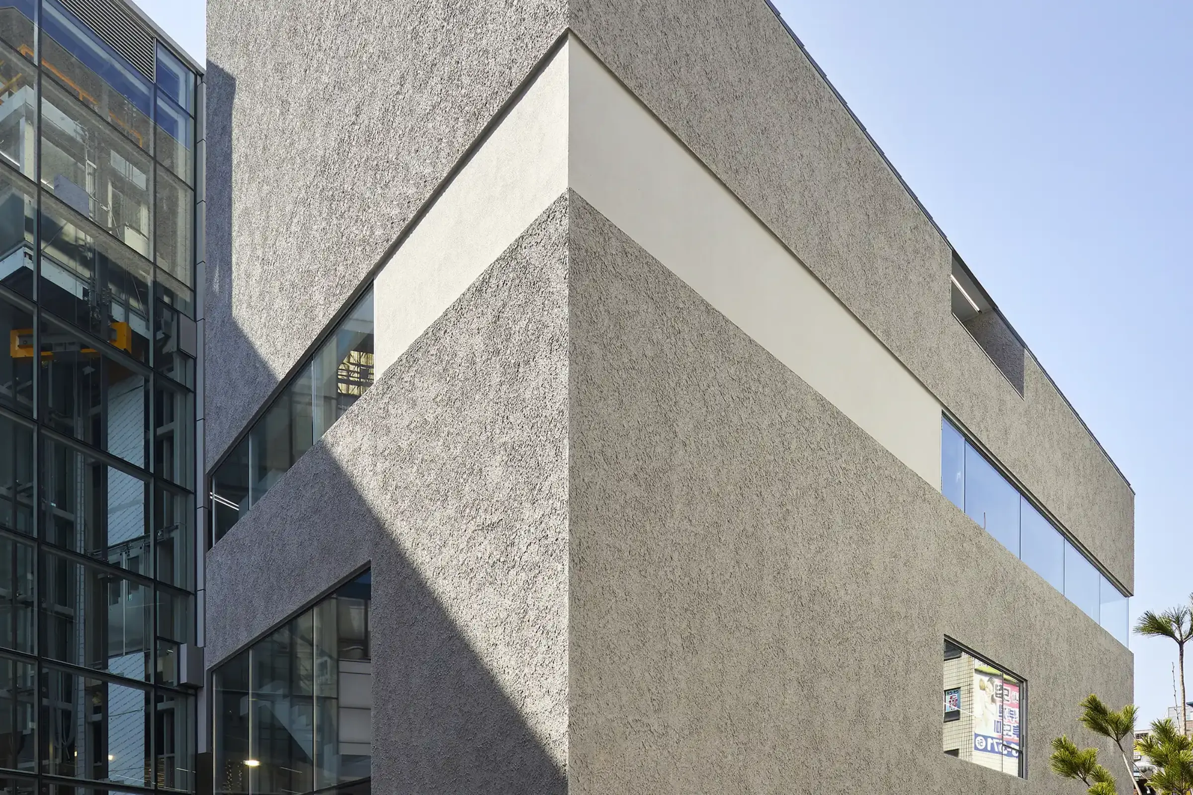 Außenaufnahme einer Nachbarschaftseinrichtung mit besonders rauer Putztextur in Grau