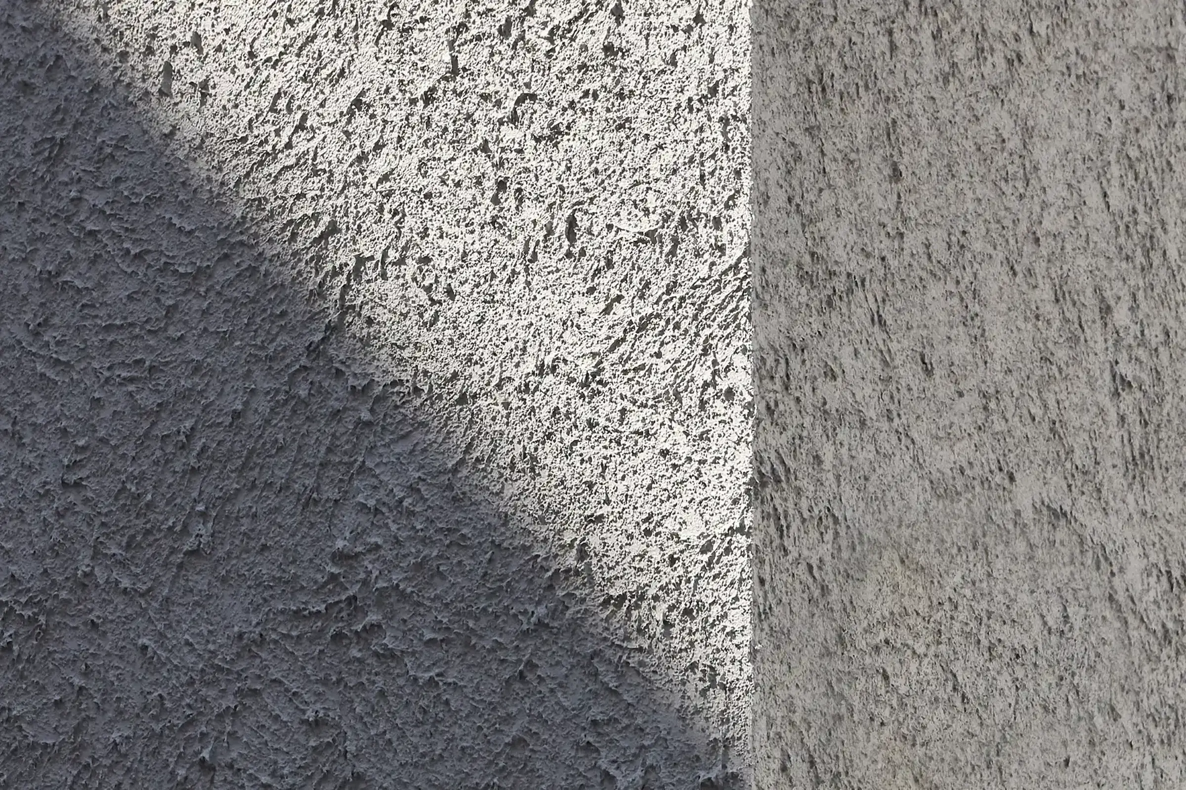 Detailaufnahme der rauen Putztextur in Grau