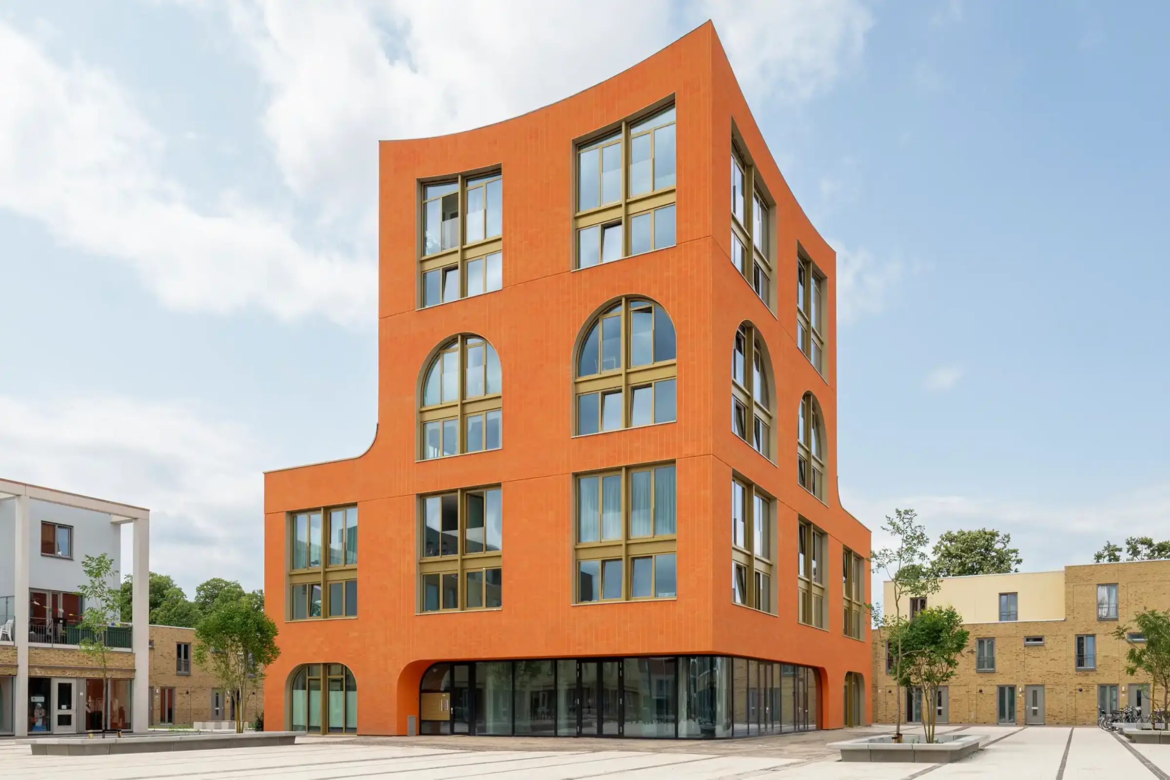 Außenaufnahme eines Mehrzweckgebäudes, kräftiges Orange, gestaltet mit StoEcoshape und StoSignature