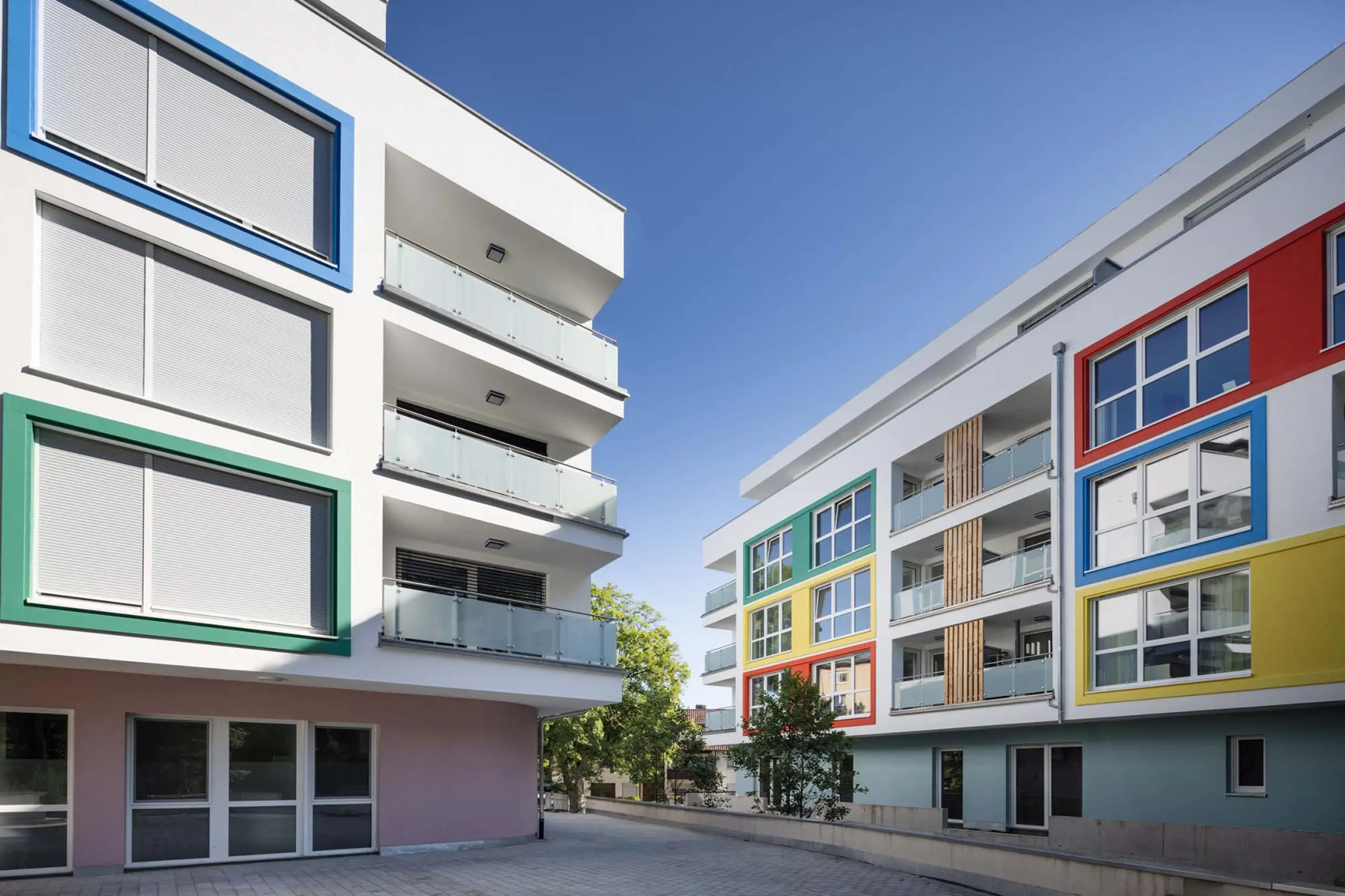 Außenaufnahme eines Wohngebäudes mit bunten Fensterumrandungen aus StoDeco Fassadenelementen