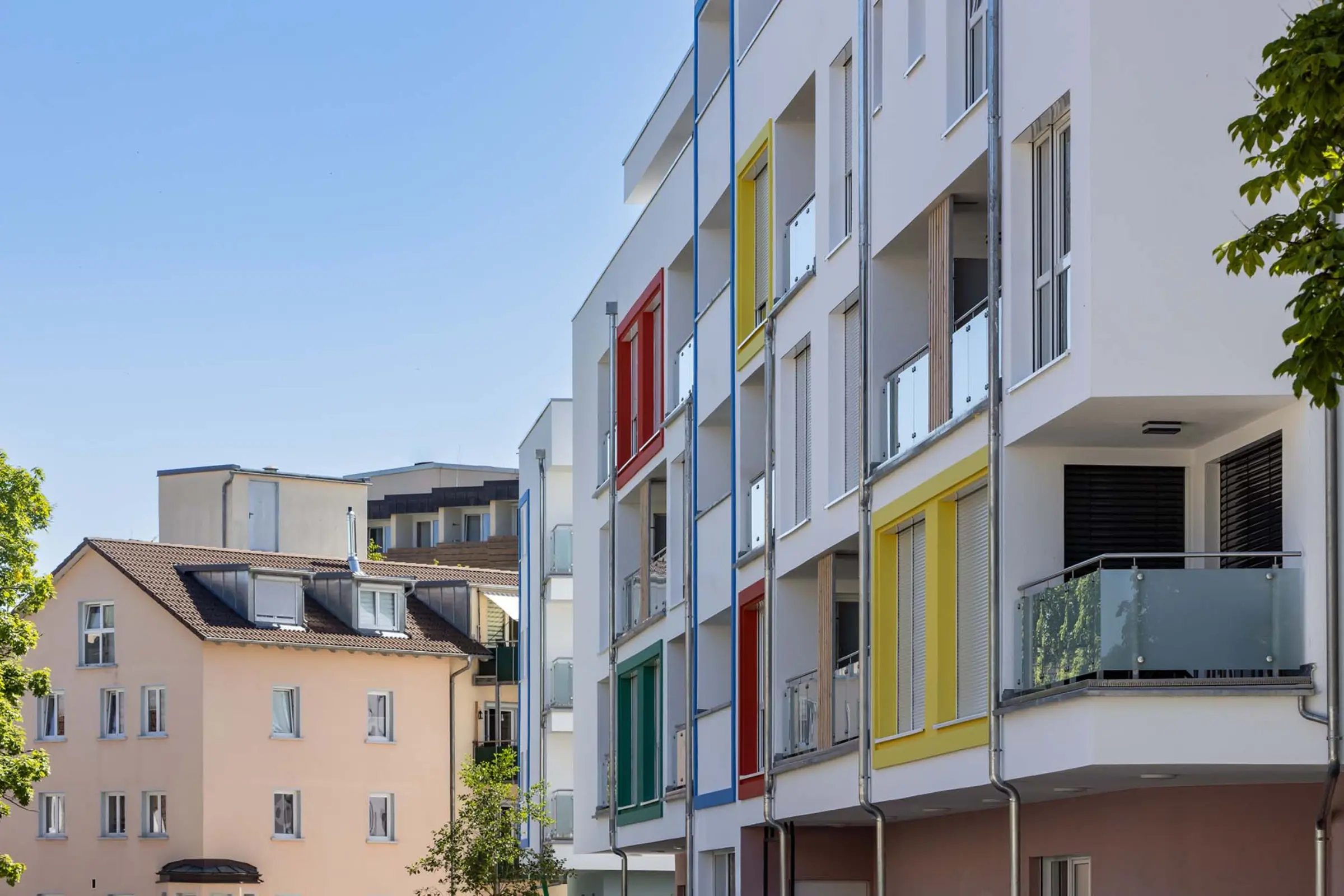 Außenaufnahme eines Wohngebäudes mit bunten Fensterumrandungen aus StoDeco Fassadenelementen