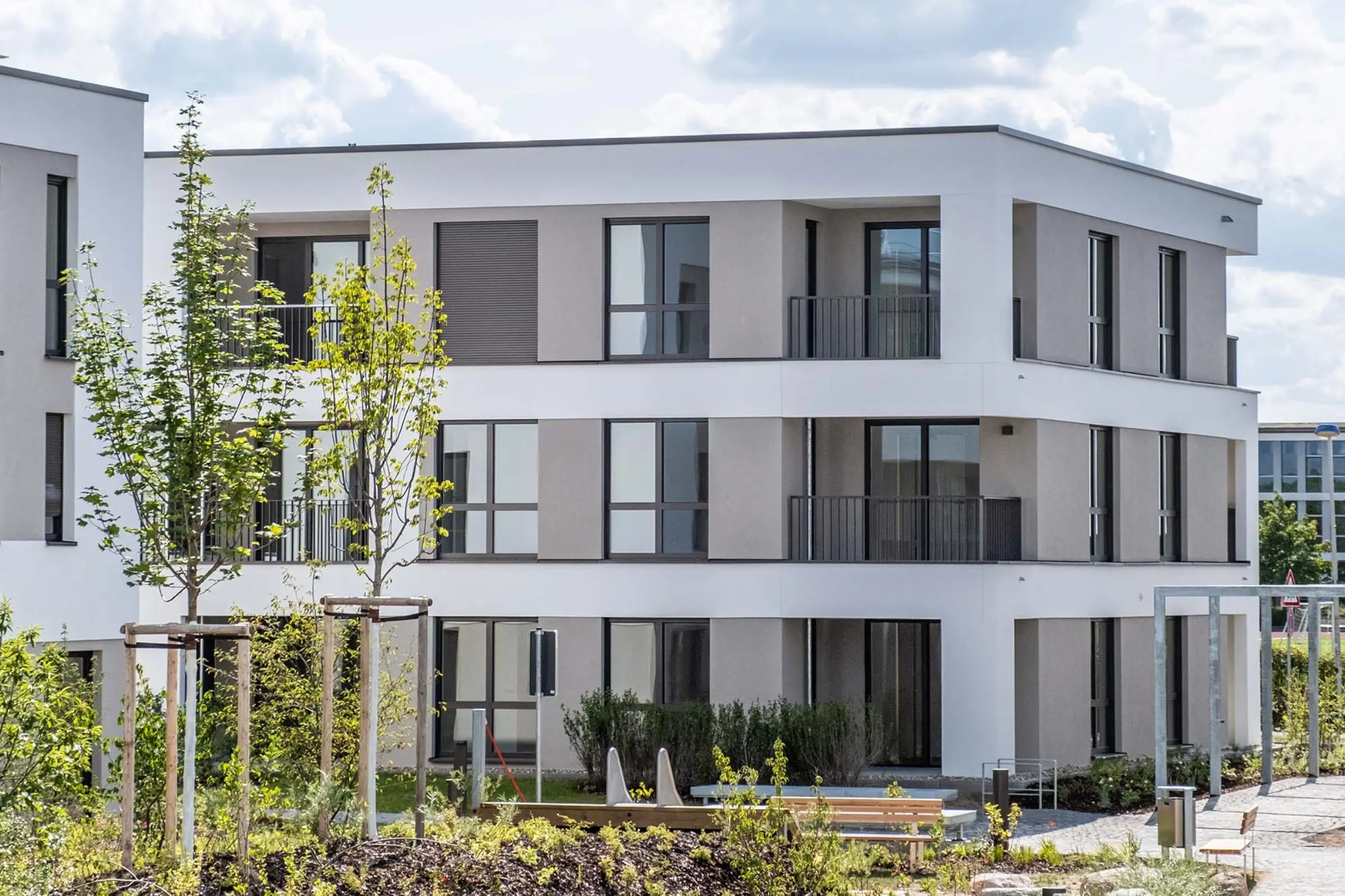 Aufnahme eines Wohnparks, weiße Fassaden mit beigen Akzenten, Neubau mit StoTherm Vario