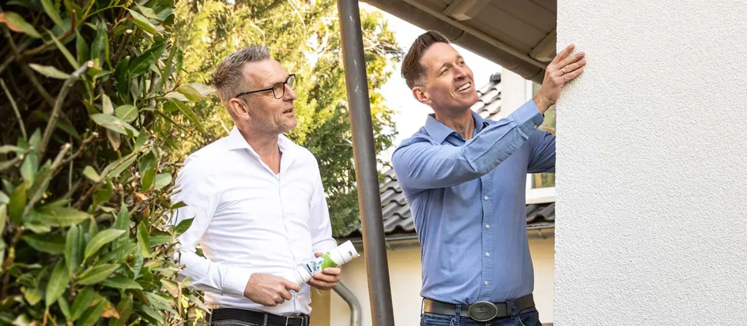 Fachhandwerkspartner von Sto im Gespräch mit einem Bauherren. Dialog am Bauprojekt. Haus