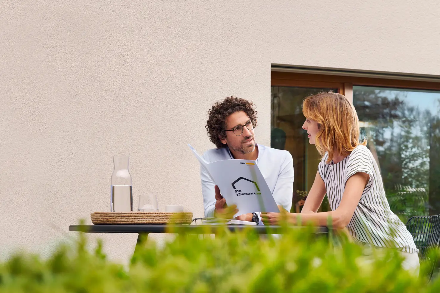Klimapartner zeigt einem Kunden etwas an der Hausfassade