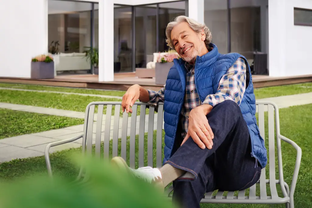 Lachende Frau auf einer Gartenterrasse