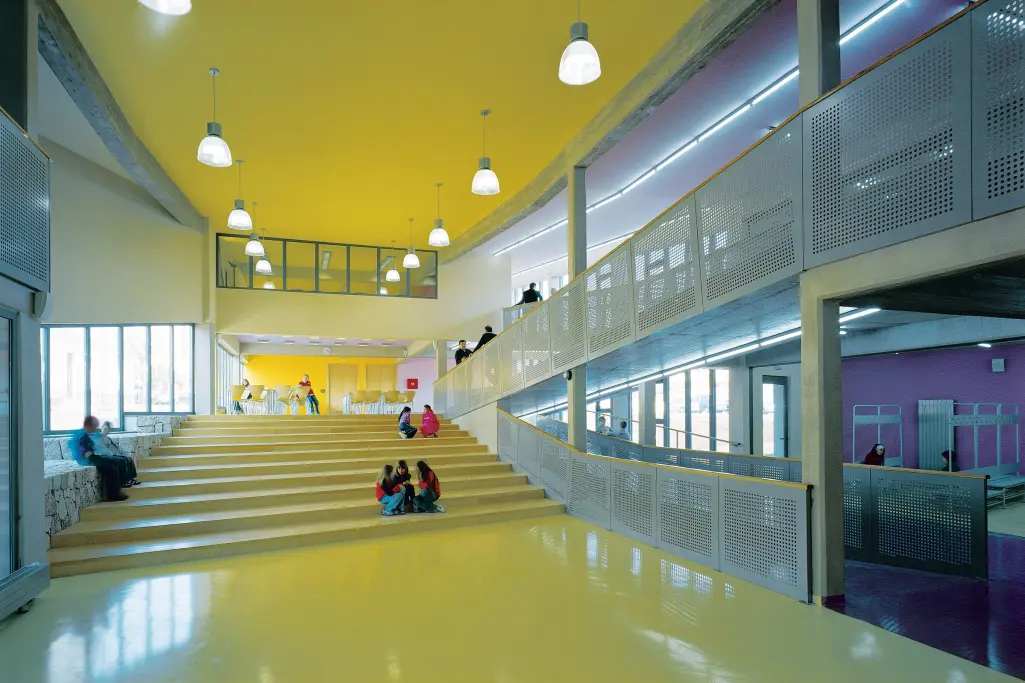 Flur der Grundschule KRK, HR. Kinder sitzen auf der gelben Treppe