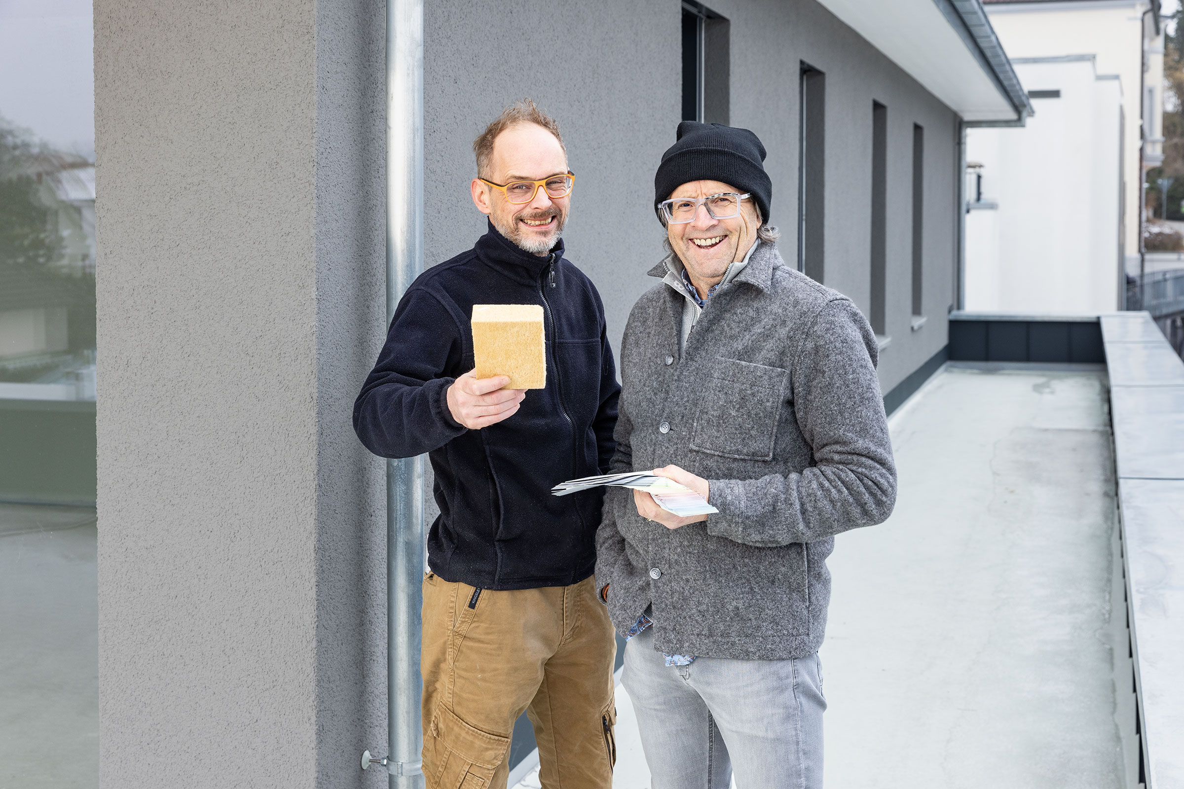 Zwei Männer im Gespräch vor einem Einfamilienhaus