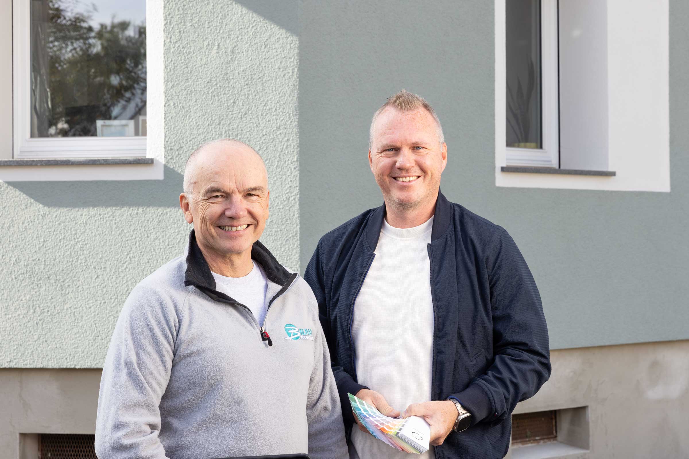 Zwei Männer im Gespräch vor einem Einfamilienhaus