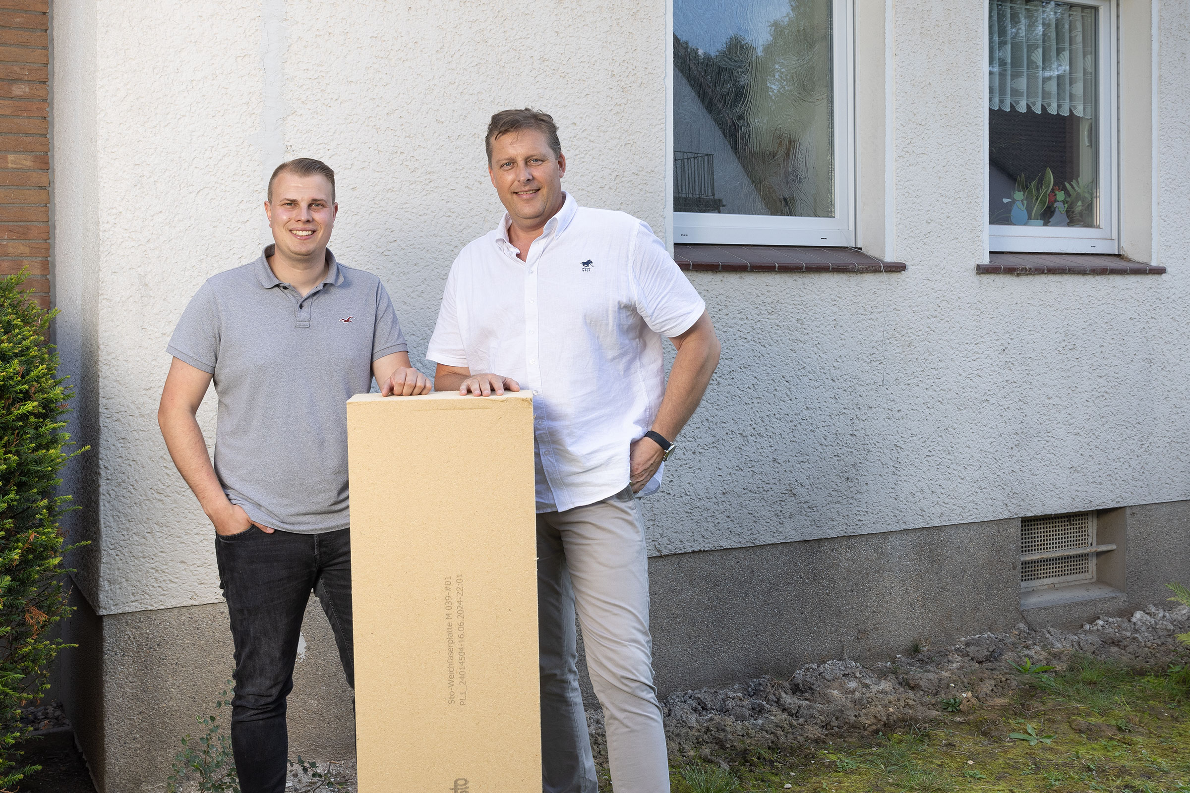 Darwin Langkamp und Frank Fechner zeigen die Holzfaserdämmplatte von StoTherm Wood.
