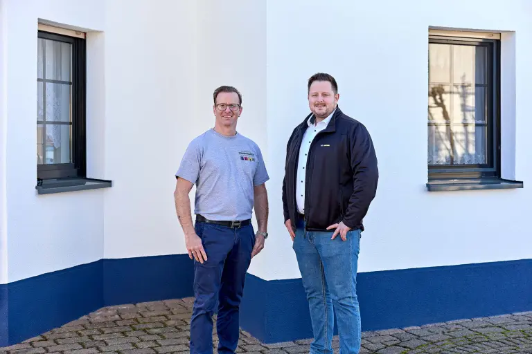 Zwei Männer vor einem Einfamilienhaus