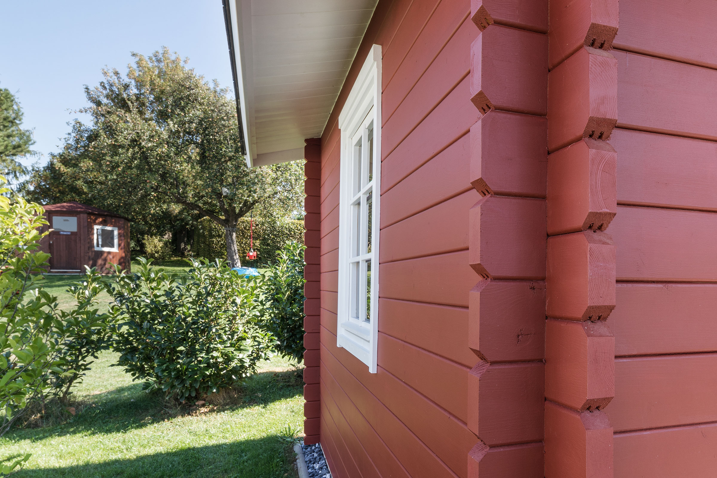 Frisch gestrichenes Gartenhaus mit StoColor Dryonic® in einem roten Farbton.