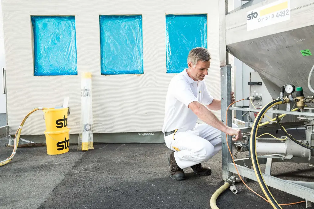 Anwendungstechniker am StoSilo Comb, Silotechnik von Sto, Sto-Eimer im Hintergrund