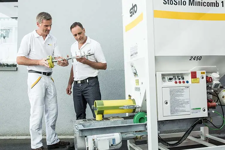 Zwei Mitarbeiter stehen vor einem StoSilo Minicomb