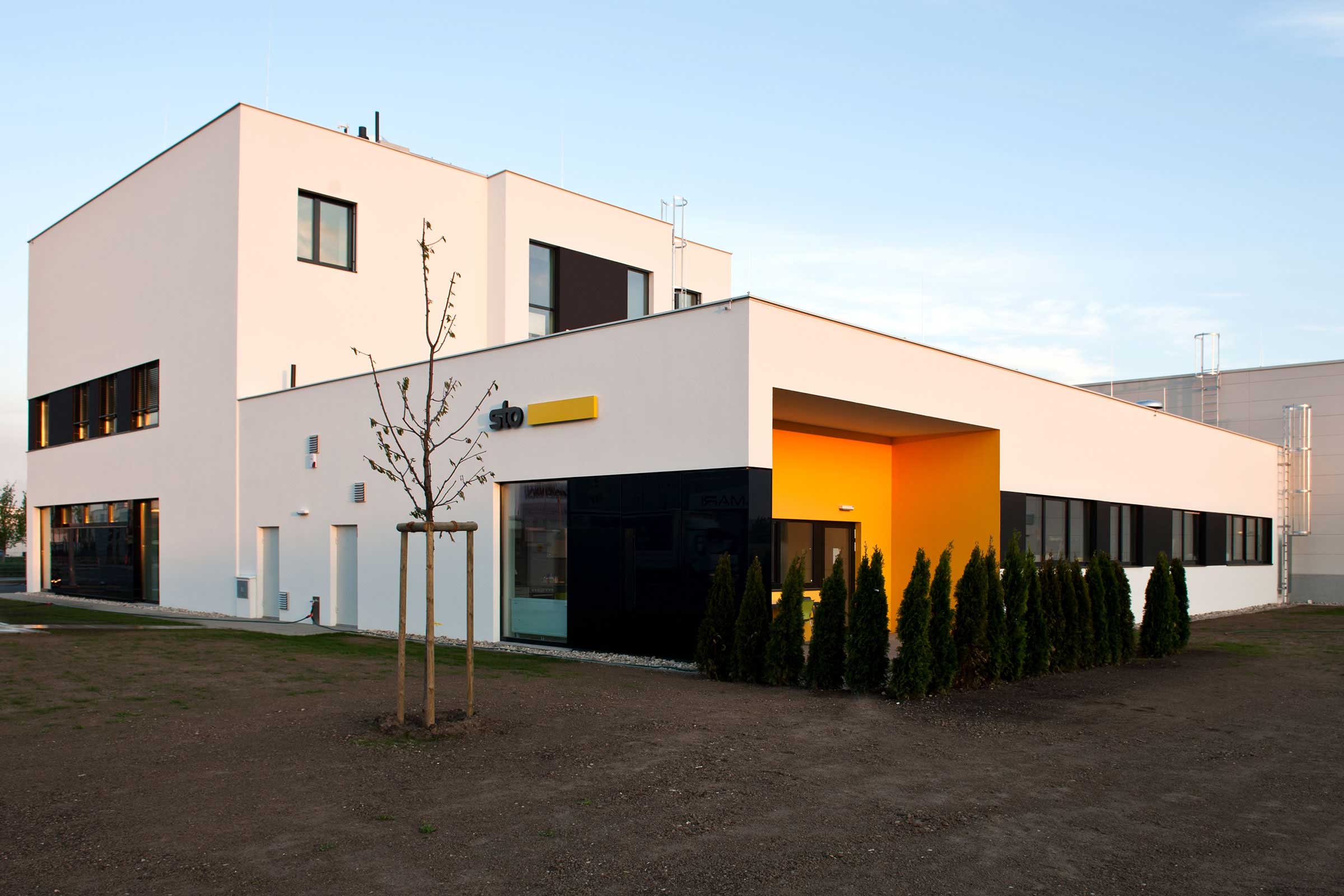 Außenaufnahme des Sto-VerkaufsCenters in Wien, Österreich, weiße Fassade mit Sto-Logo