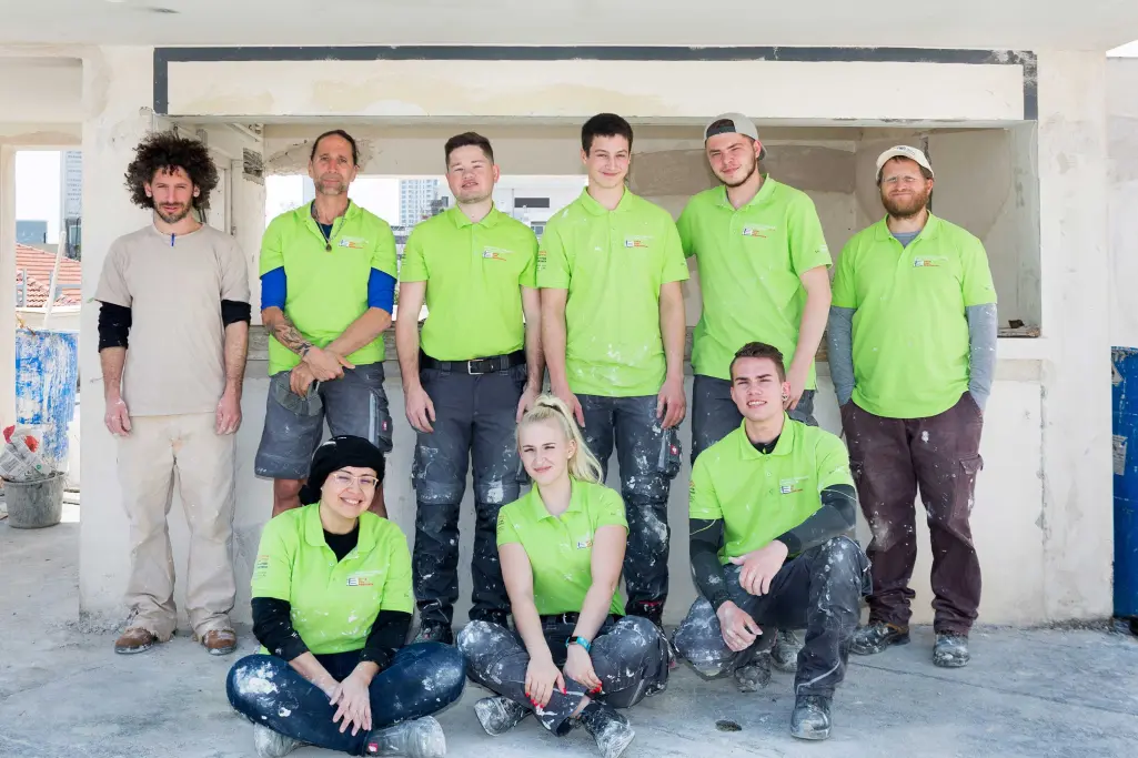 Junge Handwerker sanieren Bauhaus-Fassade in Tel Aviv.